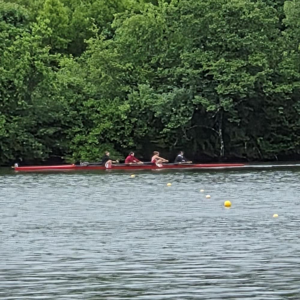 Students Rowing a Crew Boat on a Lake