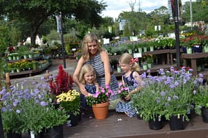 Kim with Abby and Maddy planting flowers