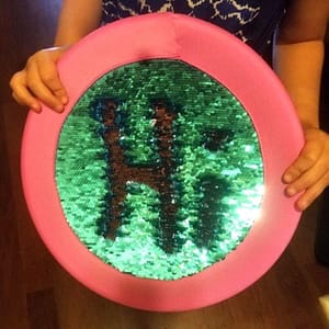 Sequin Frisbee Spelling Out the Word "Hi"
