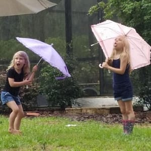 Maddy and Abby with Umbrellas in the Rain