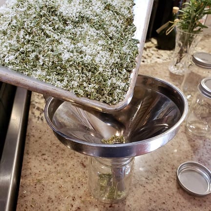Herb Salt Being Poured into a Jar Through a Funnel