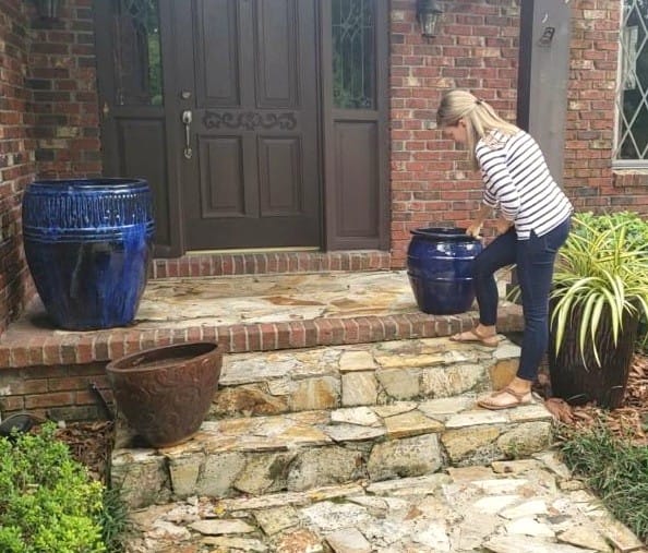 Woman Setting Up Pots on Front Porch