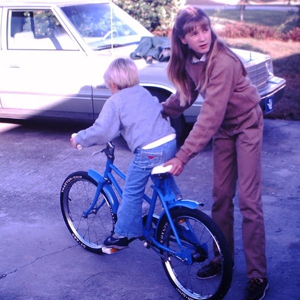Young Joey (boy) on a Blue Bike with a Girl Helping Him Ride