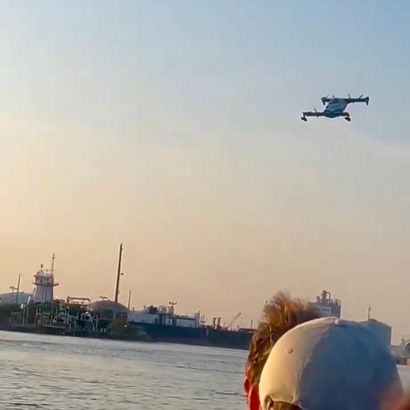 Personal Aircraft Flying Over People in a Boat and Water