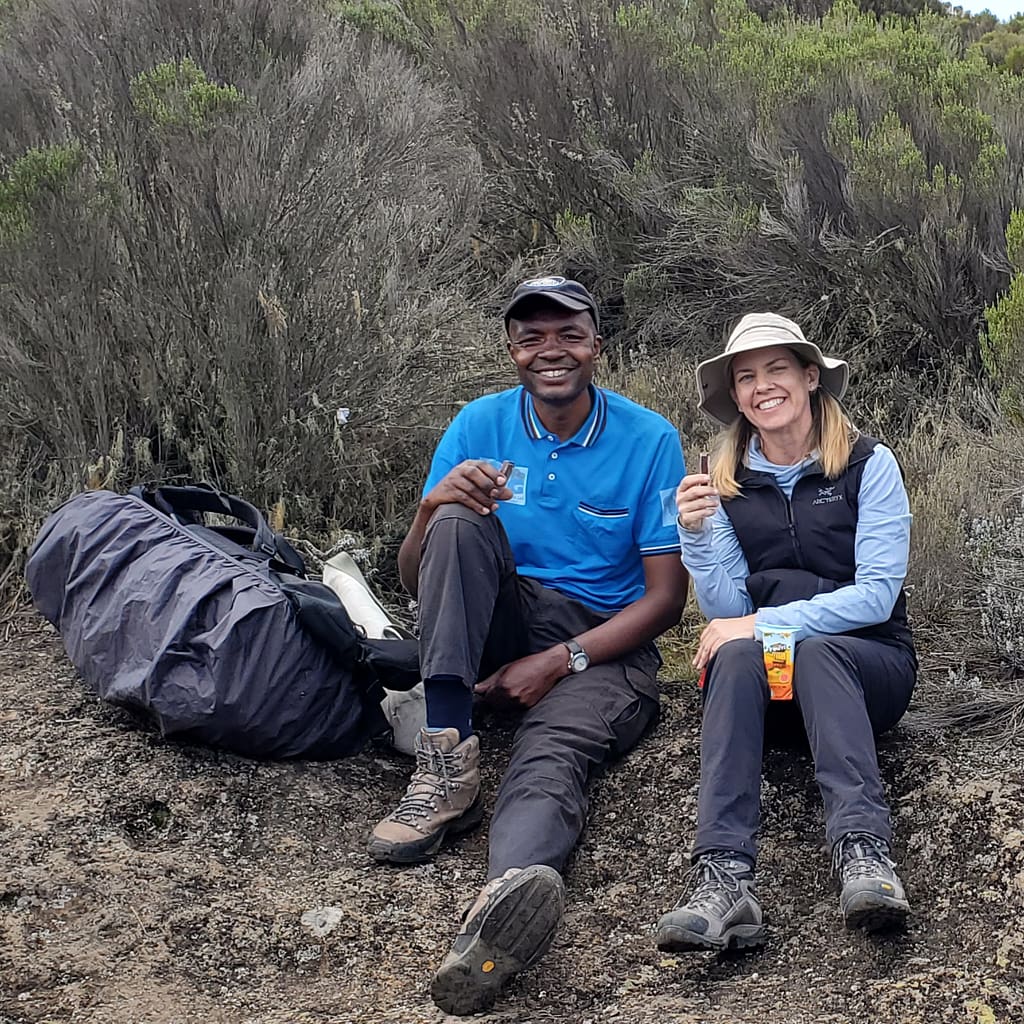 Lady (Kim) and Fellow Hiker Taking a Break During Hike of Mt. Kilimanjaro