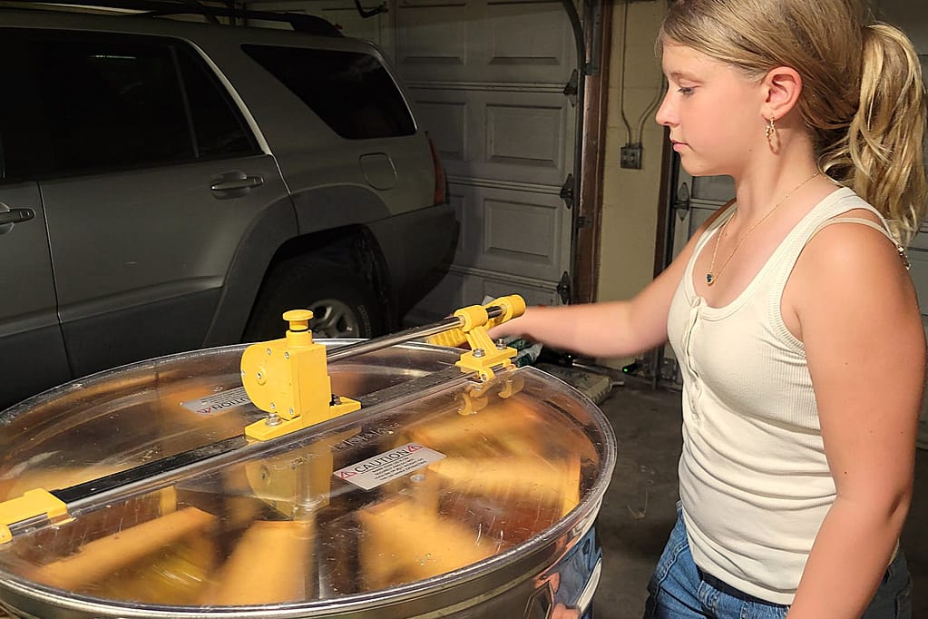 Girl (Maddy) Processing Honey in Pot from Beehive