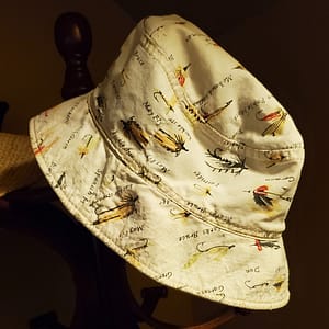 Bucket Hat with Fishing Flies Fabric Pattern, Hanging on a Rack