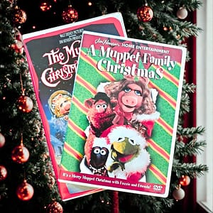 Two Muppet Christmas Movies in DVD Cases in Front of a Christmas Tree