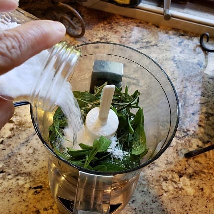 Herbs in a Food Processor with Salt Being Added