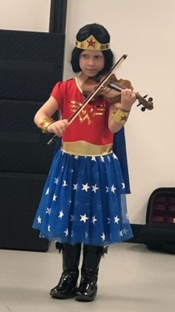 Girl (Maddy) Dressed as Wonder Woman for Halloween, Playing a Violin