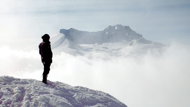 Person Standing on Top of a Mountain