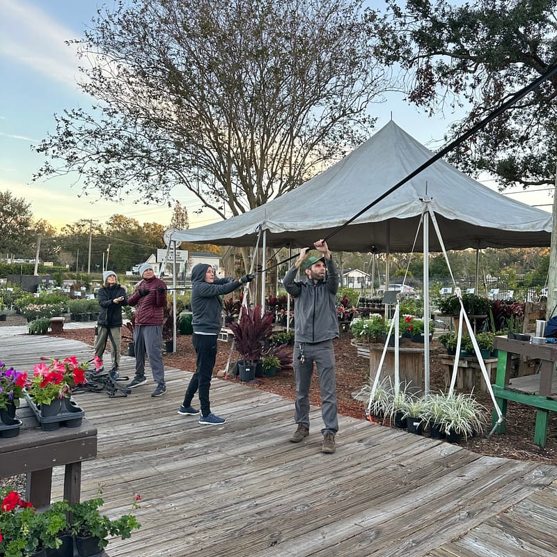 Kerby's Staff Pulling Plastic on the Greenhouse Roof