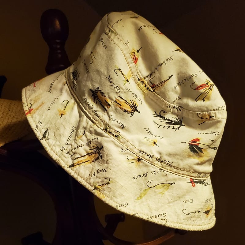 Bucket Hat with Fishing Flies Fabric Pattern, Hanging on a Rack