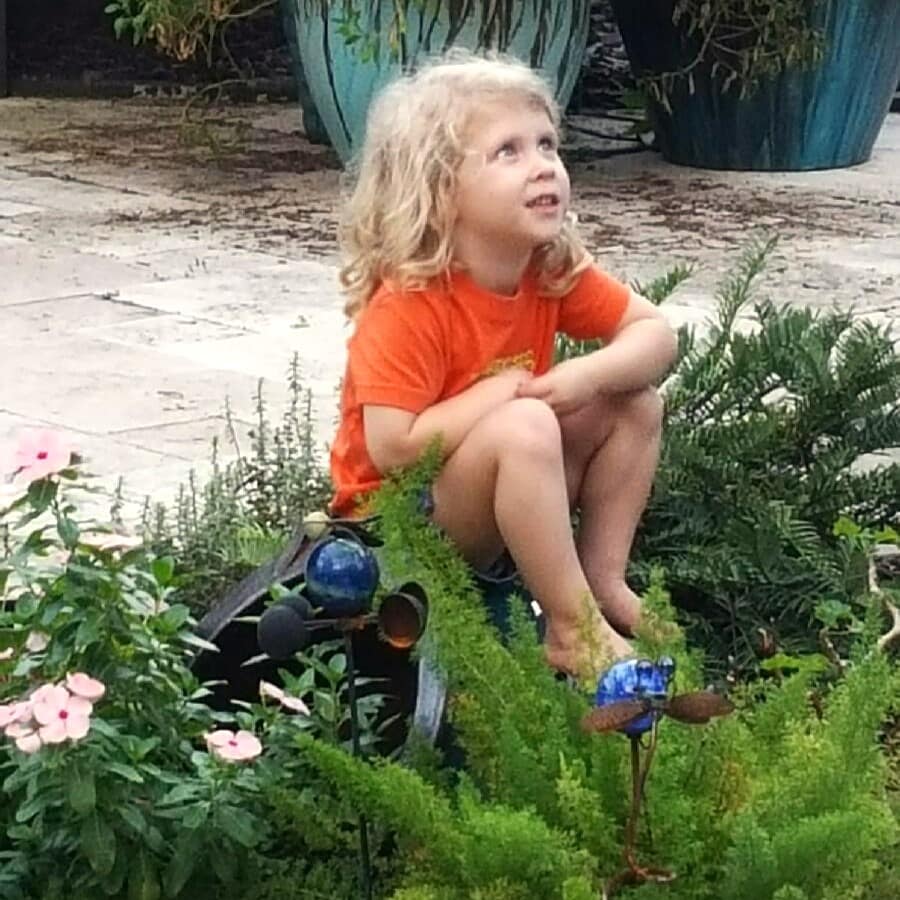 Maddy Sitting in a Garden Bed, Looking Up at the Sky