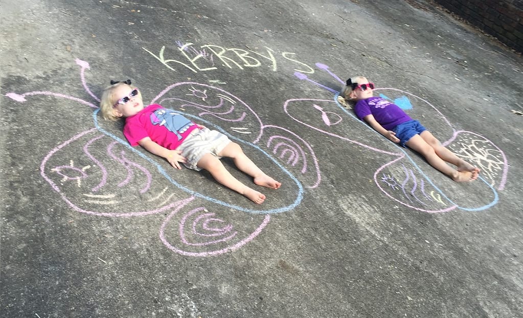 Little Girls Making Butterflies Out of Sidewalk Chalk