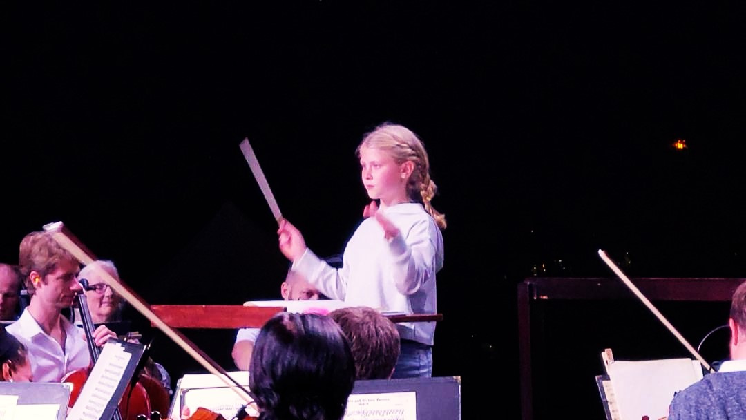 Maddy the Maestro, conducting the Florida Orchestra at Pops in the Park 2023.