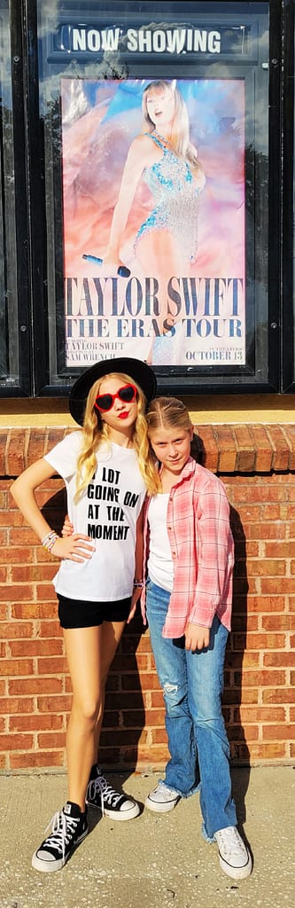 Abby and Maddy in their Taylor Swift "Eras" outfits outside the movie theater.