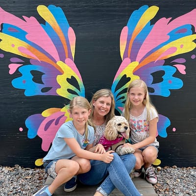 Maddy, Kim, Pearl the dog, and Abby at the Kerby's Nursery Butterfly Mural