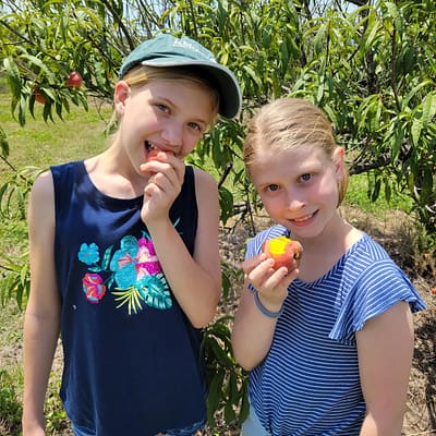 Abby and Maddy eating peaches
